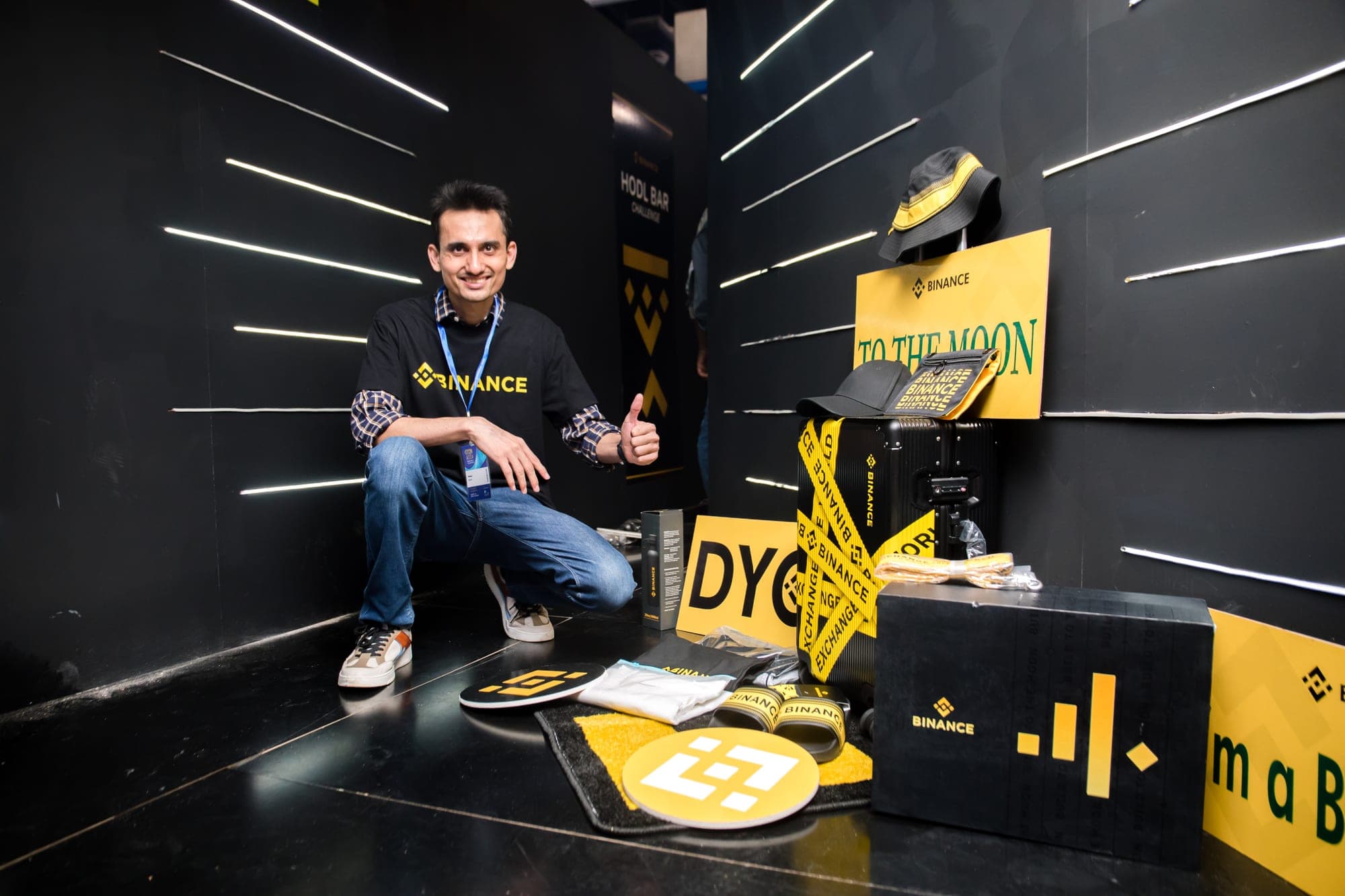 Binance representative with branded merchandise at a conference booth